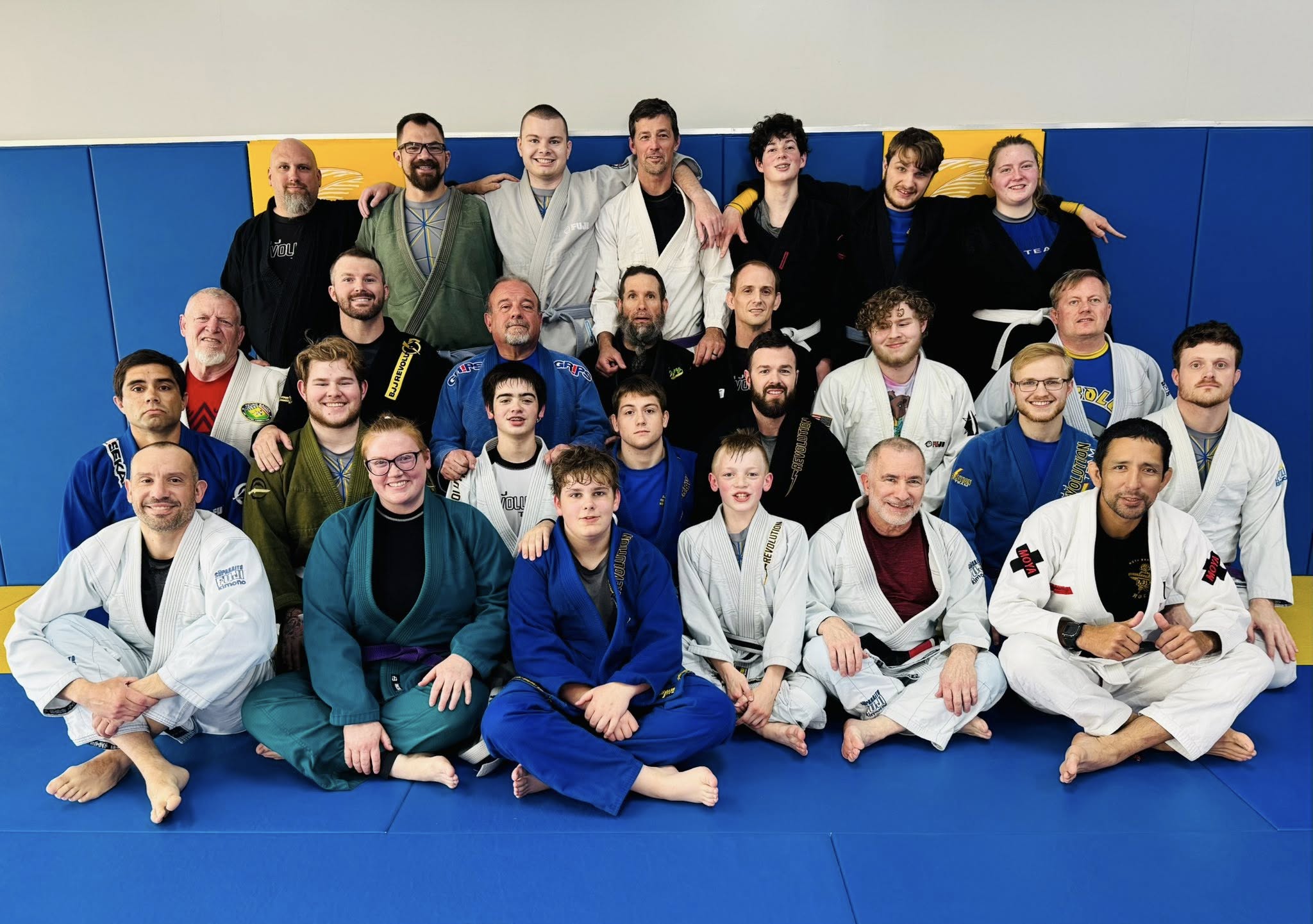Group photo of diverse martial artists and students at Absolute Jiu-Jitsu Academy.
