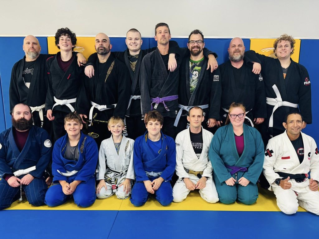 Martial arts students and instructors at Absolute Jiu-Jitsu Academy in BJJ uniforms, demonstrating skills and camaraderie.