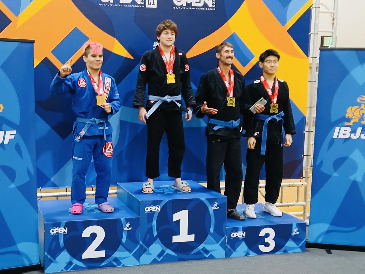 BJJ athletes winning medals at a competition, demonstrating advanced grappling skills at Absolute Jiu-Jitsu.