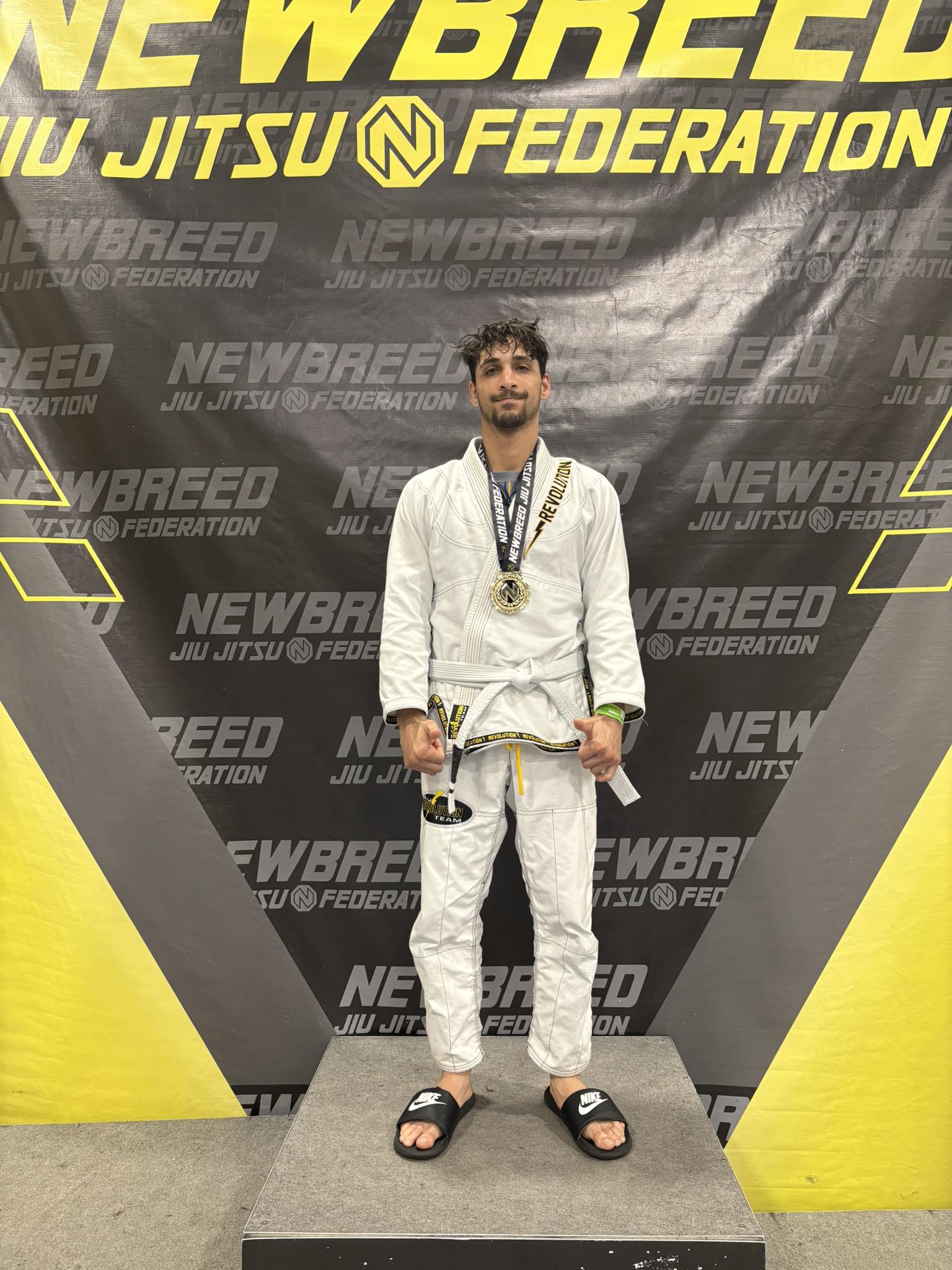 Medalist wearing gi, celebrating Brazilian Jiu-Jitsu success at New Breed.