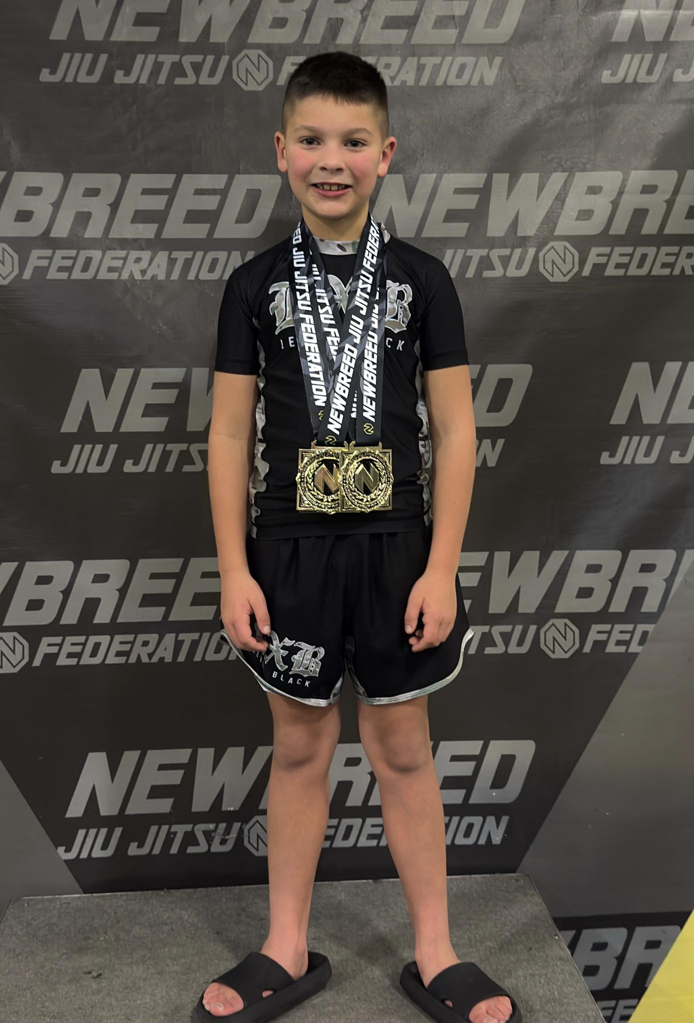Young boy with medals after BJJ competition at Absolute Jiu-Jitsu Academy in New Breed Federation.